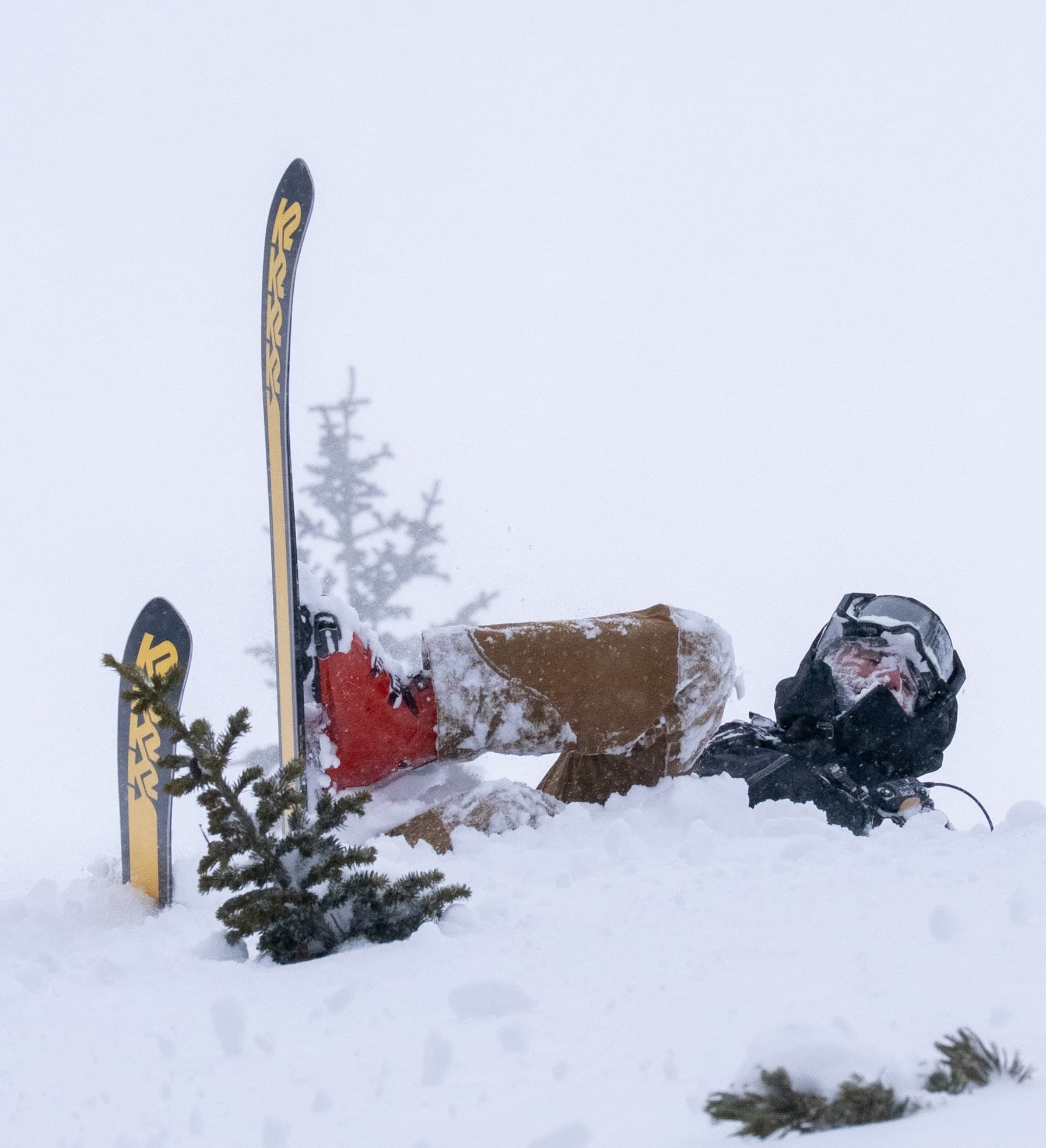 A skier upside down in deep powder after a fall near Pilots Roost.