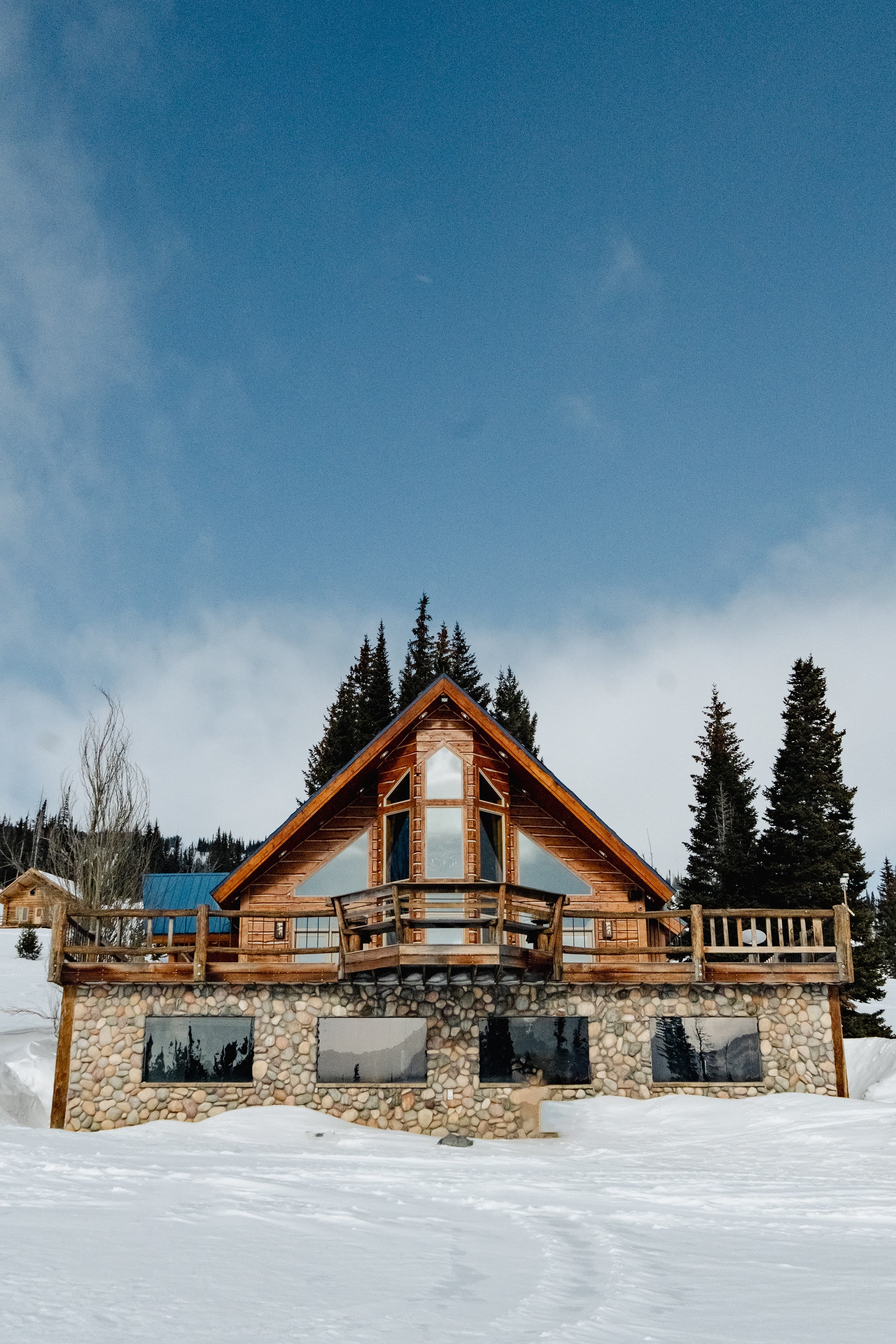 Pilots Roost A-frame and stone lodge in a snowfield under a clear winter sky.